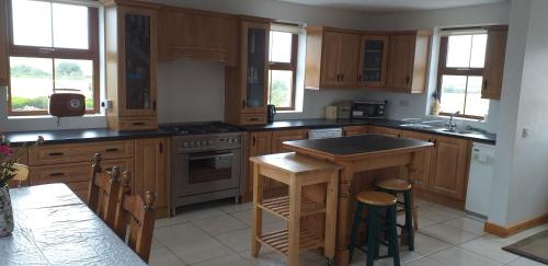 a kitchen with wooden cabinets and a island in it at Murphy s Irish Farmhouse near Ballybunion in Ballybunion