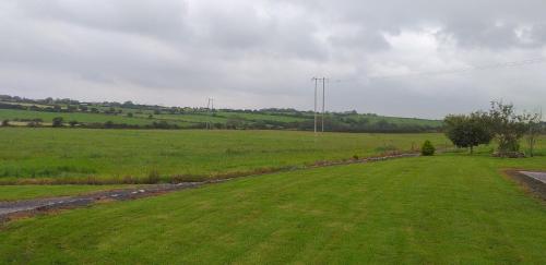 a green field with a road in the middle at Murphy's Irish farmhouse near Ballybunion in Ballybunion