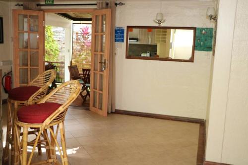 a room with chairs and a table and a mirror at Cosy House in Blue Bay with Private Parking and Terrace in Blue Bay