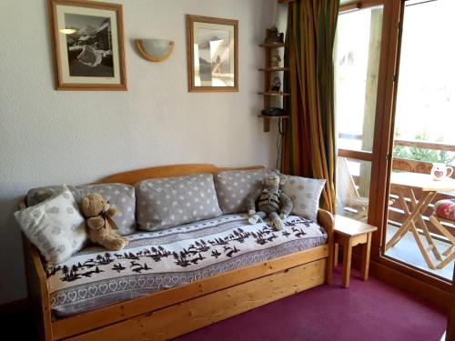 dos ositos de peluche sentados en un sofá en una sala de estar en Studio avec balcon amenage a Valloire a 1 km des pistes, en Valloire