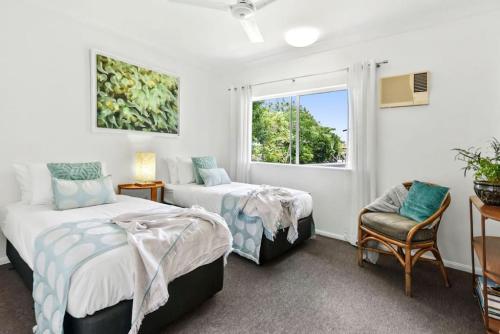 1 dormitorio con 2 camas, silla y ventana en Bohemia Heights en Westcourt