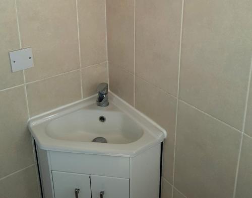 uma casa de banho com um lavatório branco num quarto em 4 berth first floor flat Glen Villa 3 em Great Yarmouth