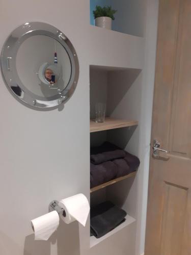a bathroom with a mirror and some towels at The Coorie Inviting 1-Bed Apartment in Oban in Oban