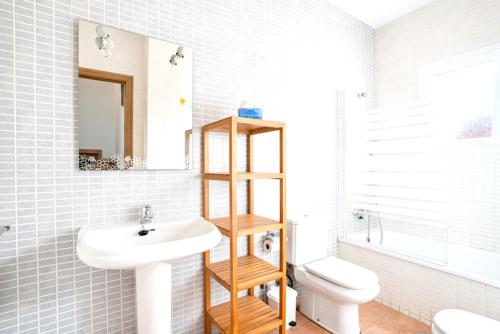 a bathroom with a sink and a toilet and a mirror at Inviting house in Lepe with shared pool. in Lepe