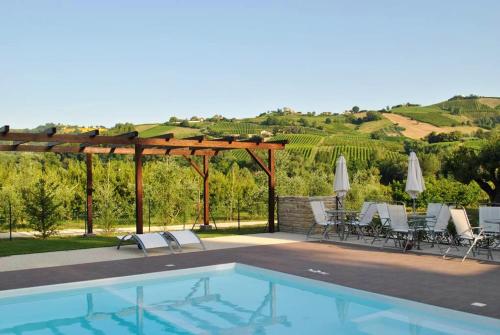 una piscina con sillas y vistas a un viñedo en One bedroom appartement with shared pool and wifi at Montalto delle Marche en Montalto delle Marche