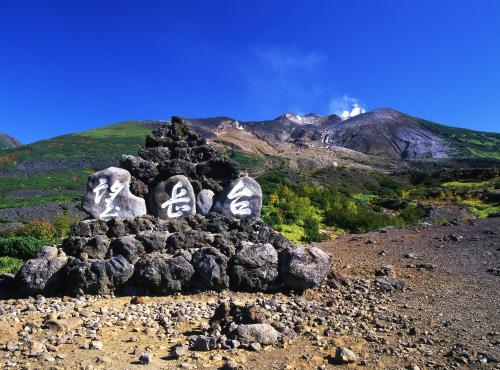 a rock formation with faces on it on a mountain at Kamihoroso in Kami-furano