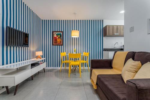 uma sala de estar com um sofá e uma mesa com cadeiras amarelas em Concept Studio a 200m PRAIA de IPANEMA e 500m Praia COPACABANA - Portaria 24h, Cozinha Completa, Ar Condicionado, SmarTV e Wi-Fi 35mbps no Rio de Janeiro