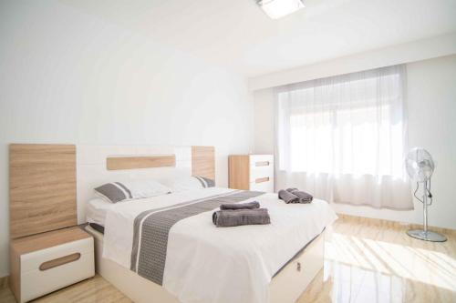 ein weißes Schlafzimmer mit 2 Betten und einem Fenster in der Unterkunft Beautiful Two Bedroom Apartment next to the beachfront in La Horadada