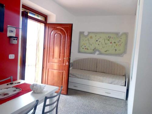 um pequeno quarto com uma mesa e uma porta com um banco em One bedroom appartement with wifi at Montegiordano 9 km away from the beach em Montegiordano