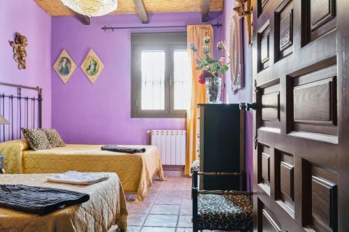 a room with two beds and purple walls at 4 bedrooms villa with private pool enclosed garden and wifi at Valverde de Leganes in Valverde de Leganés