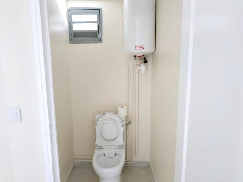 a small bathroom with a toilet and a window at Studio avec jardin clos et wifi a Le Lamentin a 5 km de la plage in Le Lamentin