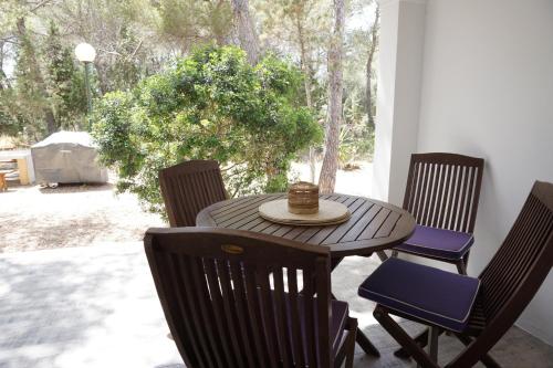 プラヤ・ミジョーンにある2 bedrooms house at Platja de Migjorn 600 m away from the beach with furnished garden and wifiのパティオテーブル(椅子、帽子付)