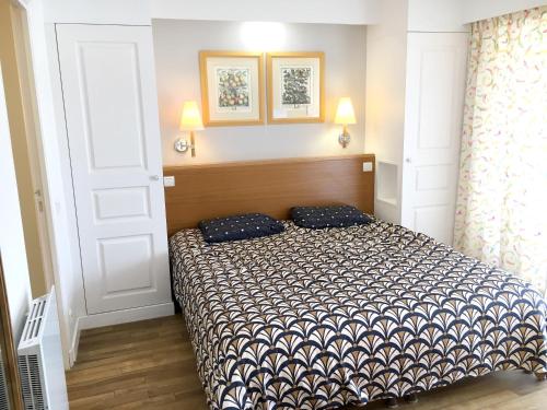 1 dormitorio con 1 cama y 2 almohadas en Appartement cosy à Saint-André-des-Eaux de 47 m² avec jardin, en Saint-André-des-Eaux