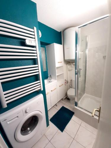 La salle de bains est pourvue d'un lave-linge et d'une douche. dans l'établissement Appartement charmant à Bandol 30 m² avec vue sur la mer., à Bandol