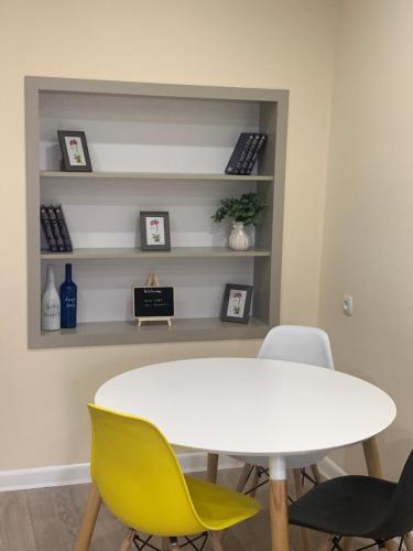 een eetkamer met een witte tafel en gele stoelen bij Art Apart 5 in Jerevan