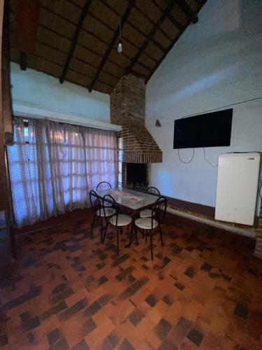 a dining room with a table and chairs and a tv at Apartamentos Laguna Merin Rincón del Lago in Lago Merin