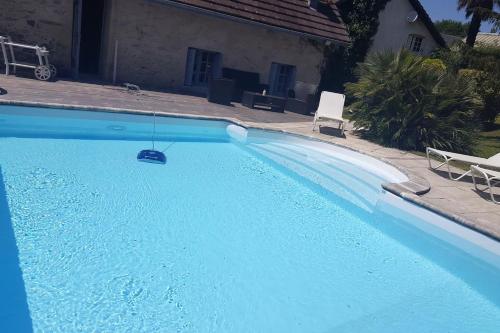 a large blue swimming pool with a swing at Villa spacieuse avec piscine à Aspin-en-Lavedan, vue montagne. in Aspin-en-Lavedan