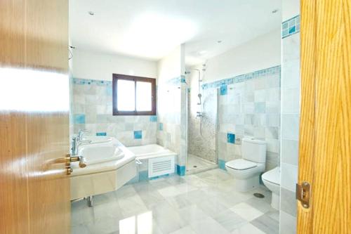 y baño con lavabo, bañera y aseo. en 5 bedrooms villa with private pool jacuzzi and furnished terrace at Marbella, en Marbella