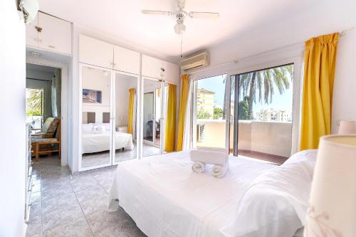 a bedroom with a white bed and a large window at Sea View Apartment in Benalmádena, Shared Pool in Benalmádena