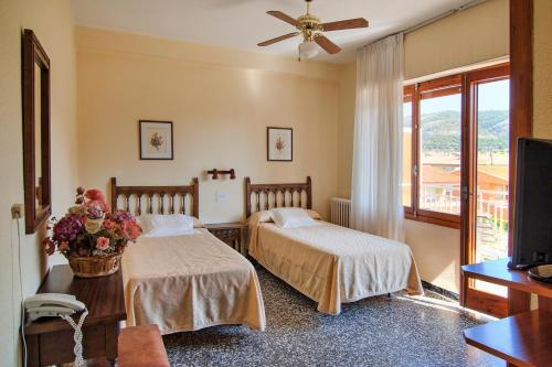 una camera d'albergo con due letti e una televisione di Vista Alegre a Benicàssim