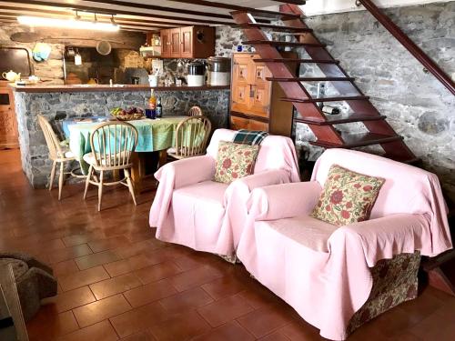 a dining room with pink chairs and a table at 2 bedrooms house with sea view terrace and wifi at Faja da Ovelha 2 km away from the beach in Fajã da Ovelha