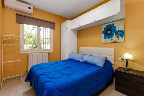 a bedroom with a blue bed and yellow walls at 2 bedrooms villa with private pool enclosed garden and wifi at Torrevieja 5 km away from the beach in La Mata