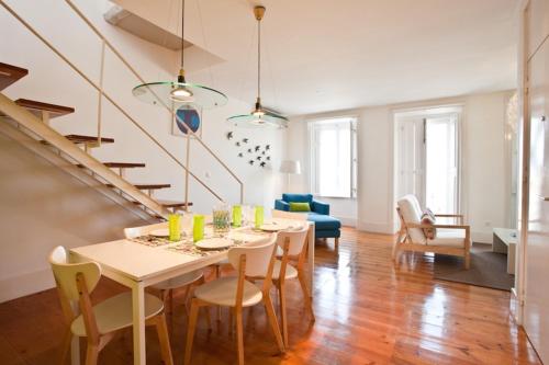 a dining room and living room with a table and chairs at Graca LIGHT in Lisbon