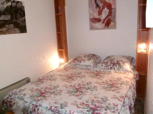 a bedroom with a bed with a floral bedspread at Appartement d'une chambre avec balcon a Enchastrayes in Enchastrayes