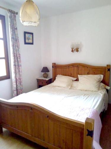 - une chambre avec un grand lit en bois et des draps blancs dans l'établissement Villa spacieuse à Lioux avec piscine privée et vue montagne, à Lioux