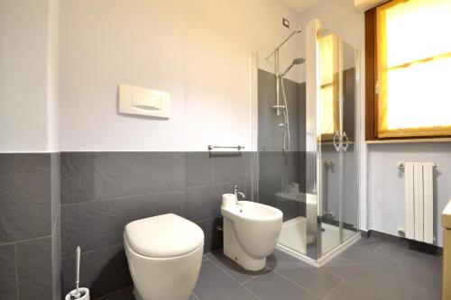 y baño con aseo y ducha acristalada. en One bedroom apartement with furnished balcony and wifi at Vercelli en Vercelli
