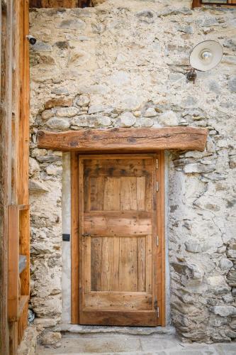 a stone wall with a wooden door on it at Agriturismo Cà Gianin in Vervio