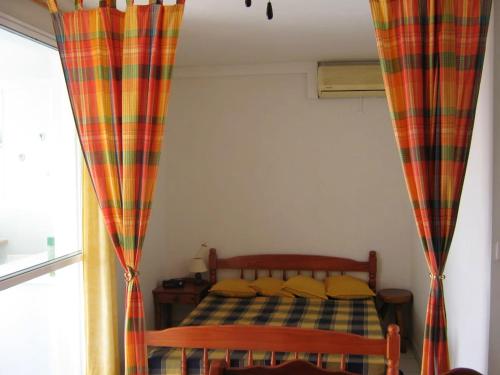 a bedroom with a bed with a checkered blanket at Maison d'une chambre avec vue sur la mer piscine partagee et jardin clos a Les Trois Ilets in Les Trois-Îlets