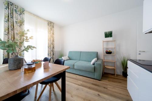 un soggiorno con divano blu e tavolo di Aosta Centre Apartments - Battaglione 10 ad Aosta