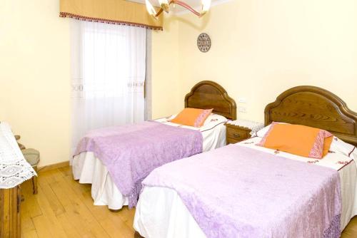 two beds in a room with purple sheets at Spacious House with Mountain View in Carboeiro de Francia in Martije
