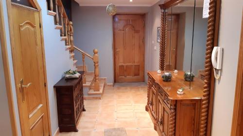 a hallway with a wooden dresser and a staircase at Spacious House with Mountain View in Carboeiro de Francia in Martije