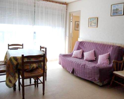 - un salon avec un lit violet et une table dans l'établissement Appartement charmant à Villers-sur-Mer, 50 m², près de la plage, à Villers-sur-Mer