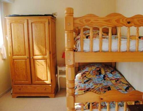 a wooden bunk bed next to a wooden cabinet at Appartement de 2 chambres a Villers sur Mer a 150 m de la plage in Villers-sur-Mer