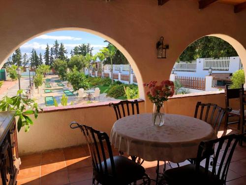 un tavolo con sedie e un vaso di fiori sul balcone di 5 bedrooms house with private pool and furnished terrace at Torre Pacheco a Torre-Pacheco