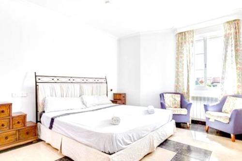 1 dormitorio con 1 cama grande y 2 sillas en 3 bedrooms villa with private pool enclosed garden and wifi at Marratxi 9 km away from the beach, en Palma de Mallorca