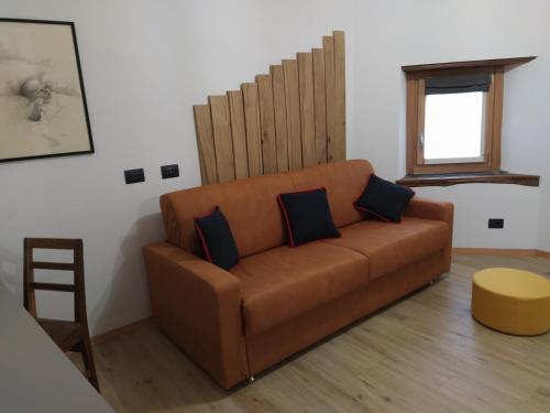 a living room with a brown couch and a window at Agriturismo Cà Gianin in Vervio