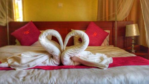 two swansuitsrendered to look like they are kissing on a bed at Precious Villas Lubowa in Kampala
