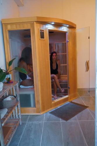 a woman sitting in a shower in a room at Domaine du Château in Les Trois-Îlets