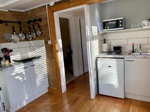 a kitchen with white cabinets and a counter top at Fourwinds B&B in March