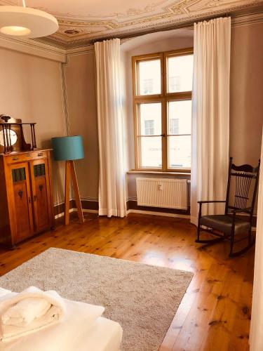 a living room with a chair and a window at Hotel Cranach-Herberge City Centre in Lutherstadt Wittenberg