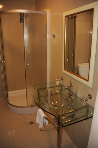 a bathroom with a glass sink and a shower at Pensiunea Velvet in Iaşi