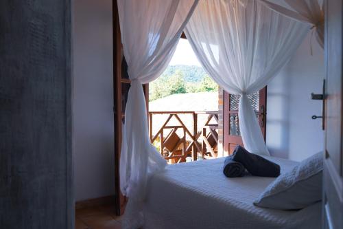 a bedroom with a bed with a view of a balcony at Domaine du Château in Les Trois-Îlets