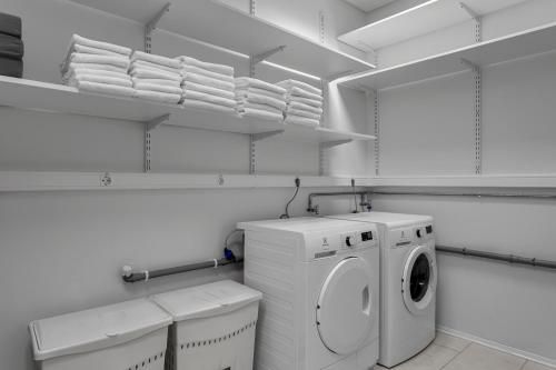 a white laundry room with a washing machine and towels at Hotel Muli in Reykjavík