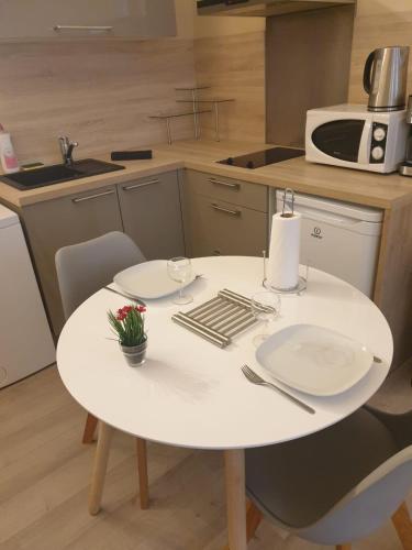 une table blanche et des chaises dans une cuisine dans l'établissement Modern Studio Centre Ville D'avignon, à Avignon
