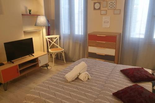 - une chambre avec un lit, une télévision et une chaise dans l'établissement Modern Studio Centre Ville D'avignon, à Avignon