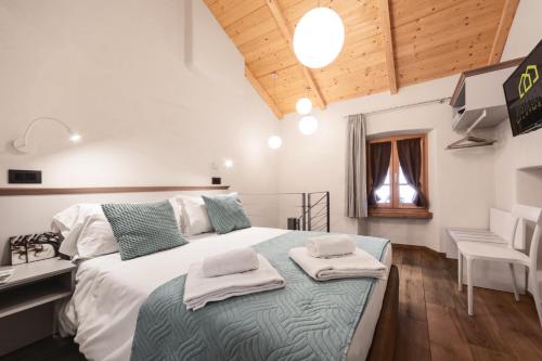 1 dormitorio con 1 cama grande y toallas. en Aosta Centre Apartments - Martinet 17 en Aosta